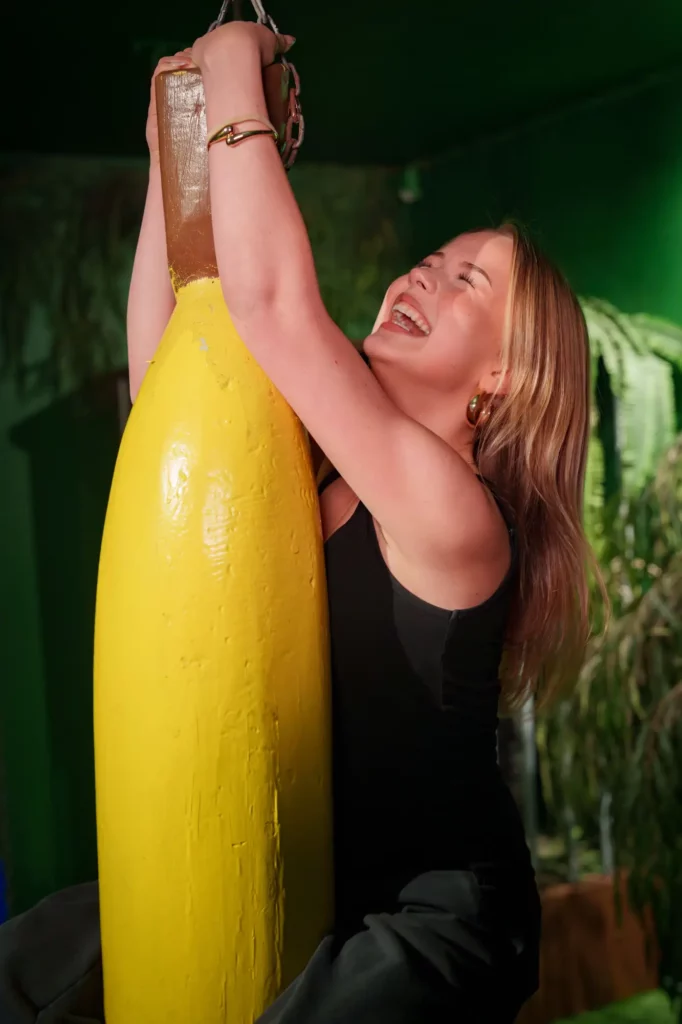 Glad tjej hänger i en banan.