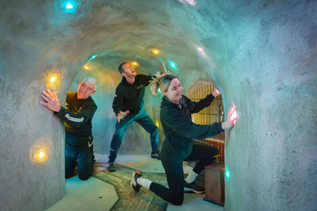 Tre personer i en glittrande grotta.