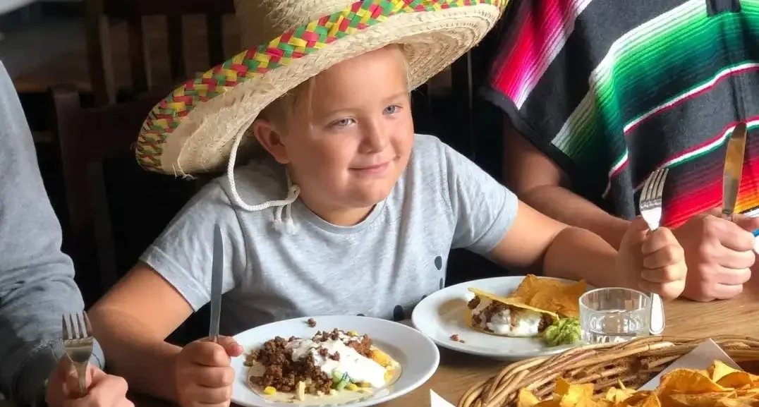 Kille i sombrero äter tacos