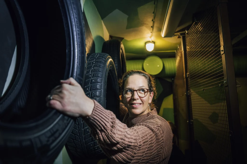 Glasögonprydd, glad kvinna klättrar i bildäck längs en vägg