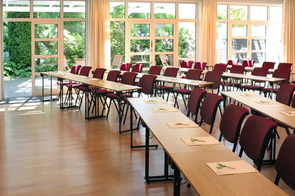 röda stolar och bord i ett stort konferensrum