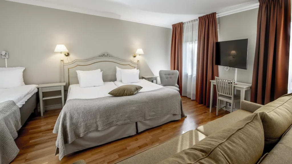 hotellrum med stor dubbelsäng, enkelsäng och en soffa