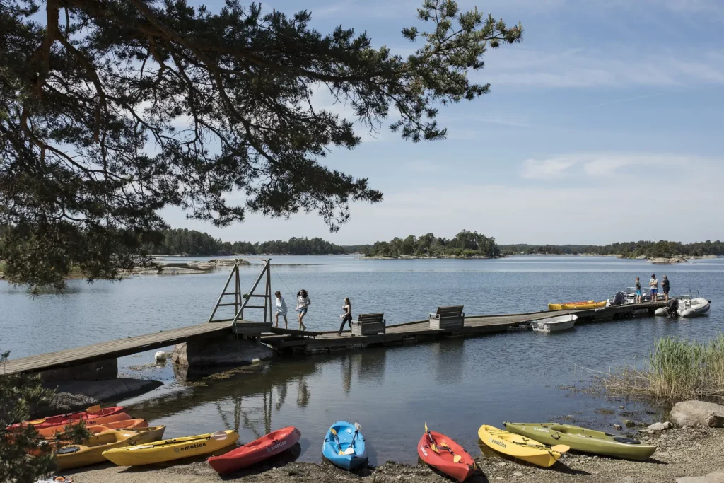 badbrygga med kanoter uppradade på stranden