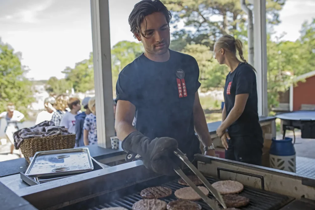 Kille grillar hamburgare