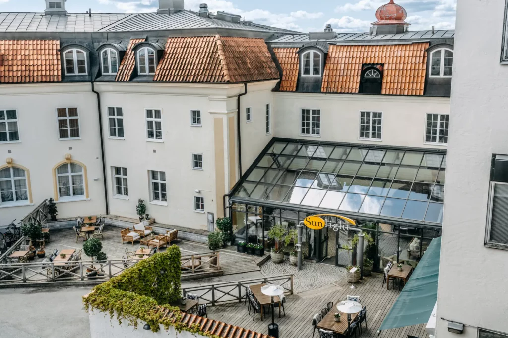 Entrén till Sunlight hotell och deras uteservering med bord och sittgrupper på ett trädäck
