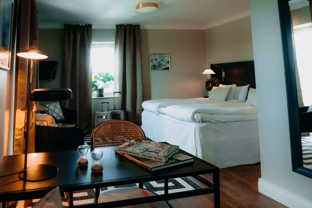 Hotellrum med dubbelsäng, fåtöljer och ett skrivbord