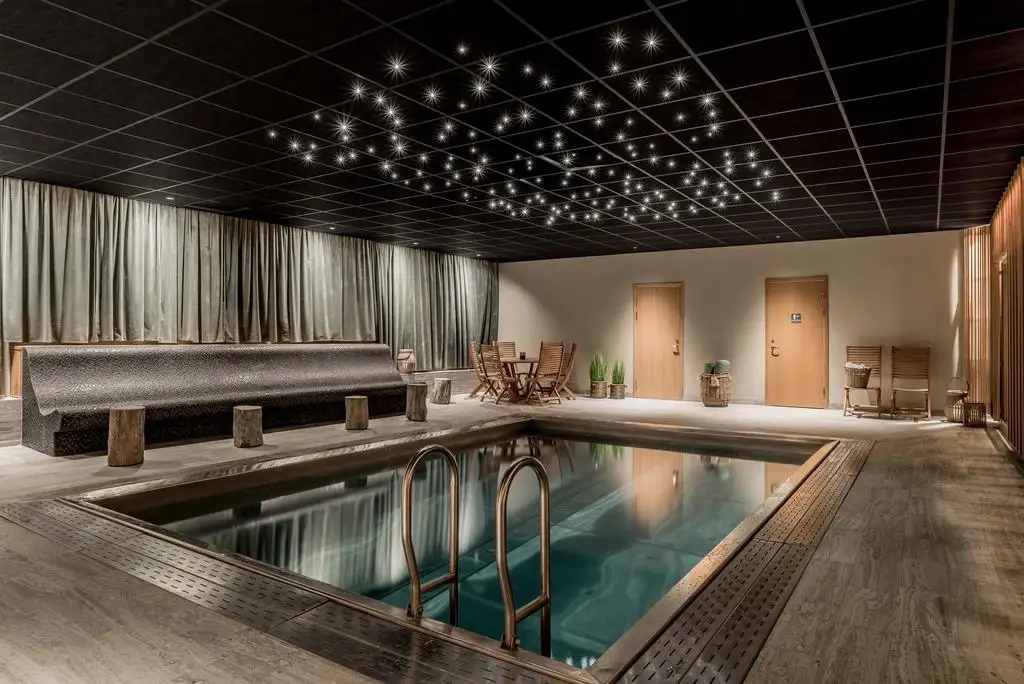 pool i en relaxavdelning med svart tak och solstolar