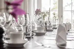 Findukat bord på en restaurang med vita servetter, vinglas och kaffekoppar
