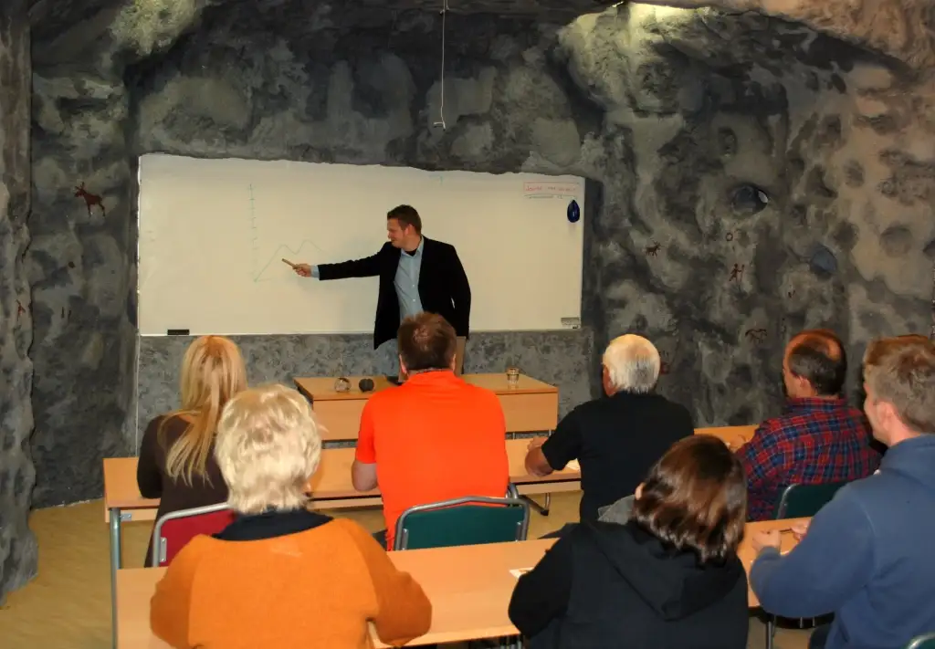 Personer som sitter i en konferenssal och lyssnar på en föredragshållare